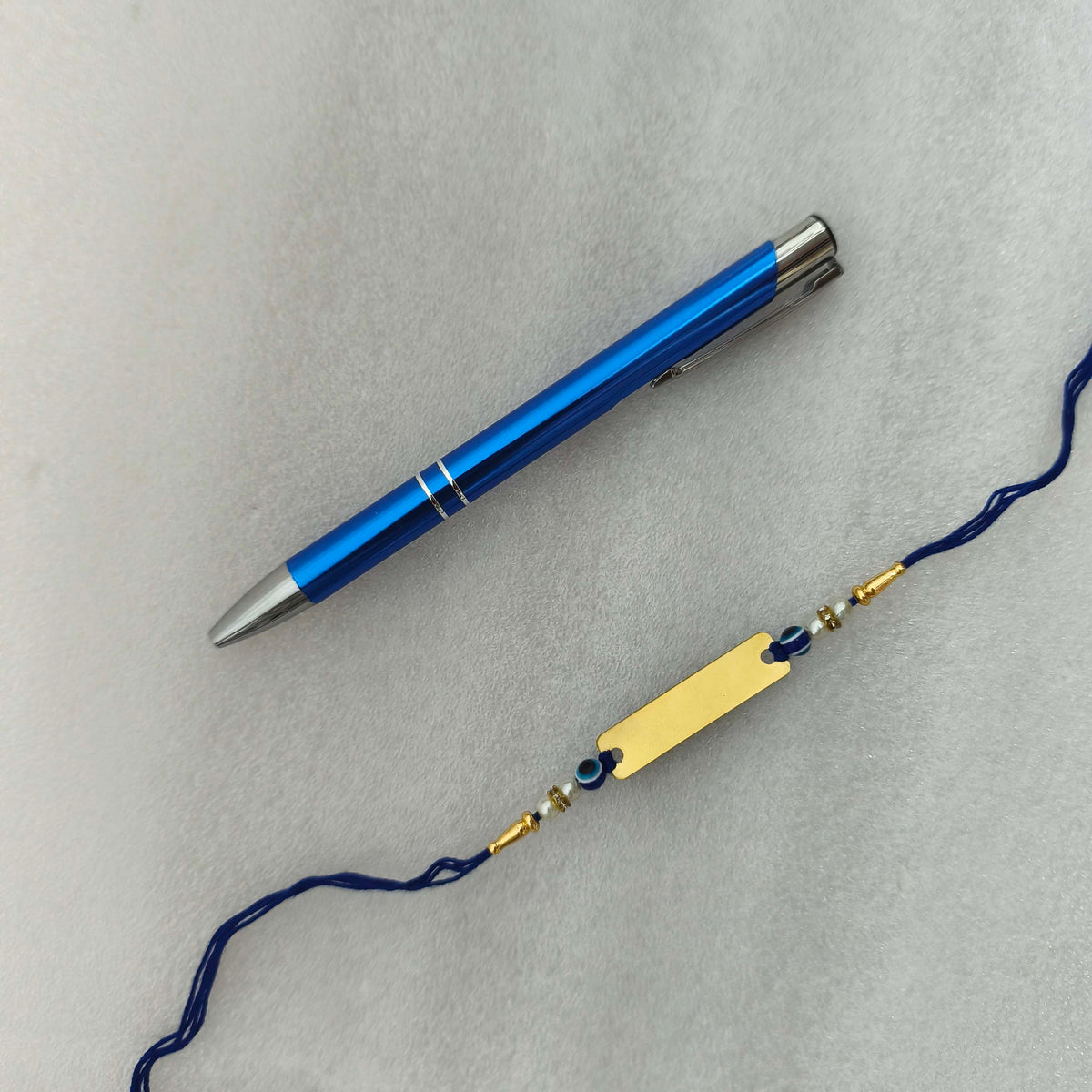 Personalized Gold-Plated Name Rakhi & Engraved Blue Metal Pen Combo Set | Custom Name in 10+ Indian Languages