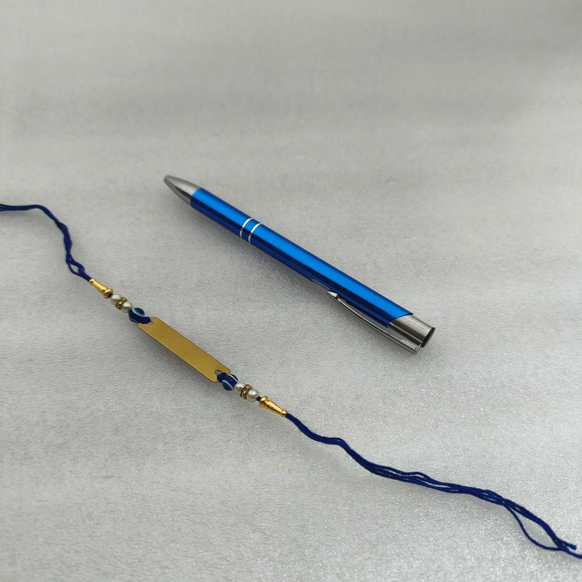 Personalized Gold-Plated Name Rakhi & Engraved Blue Metal Pen Combo Set | Custom Name in 10+ Indian Languages
